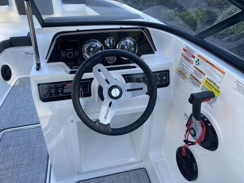 Slide: The Image of 2023 Bayliner DX2050 boat dashboard with steering wheel and control panel. - 14