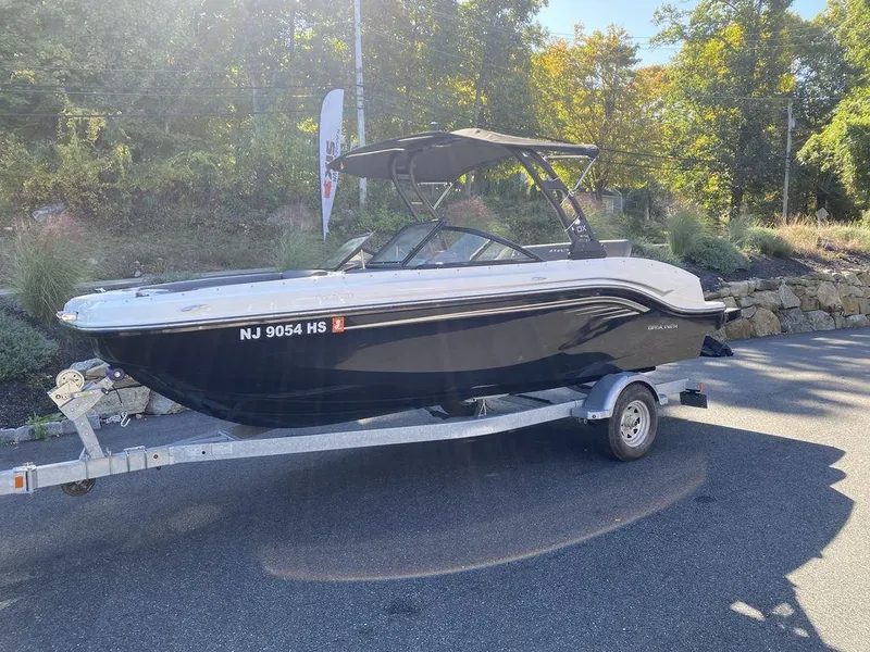 Slide: The Image of 2023 Bayliner DX2050 boat on trailer, parked outdoors. - 6