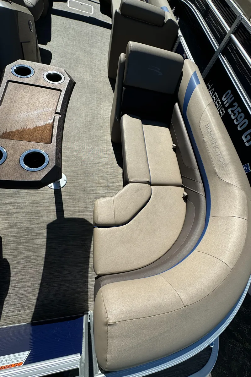 Slide: The Image of 2022 Bennington Cruiser 230 interior with beige seating and cupholders. - 10