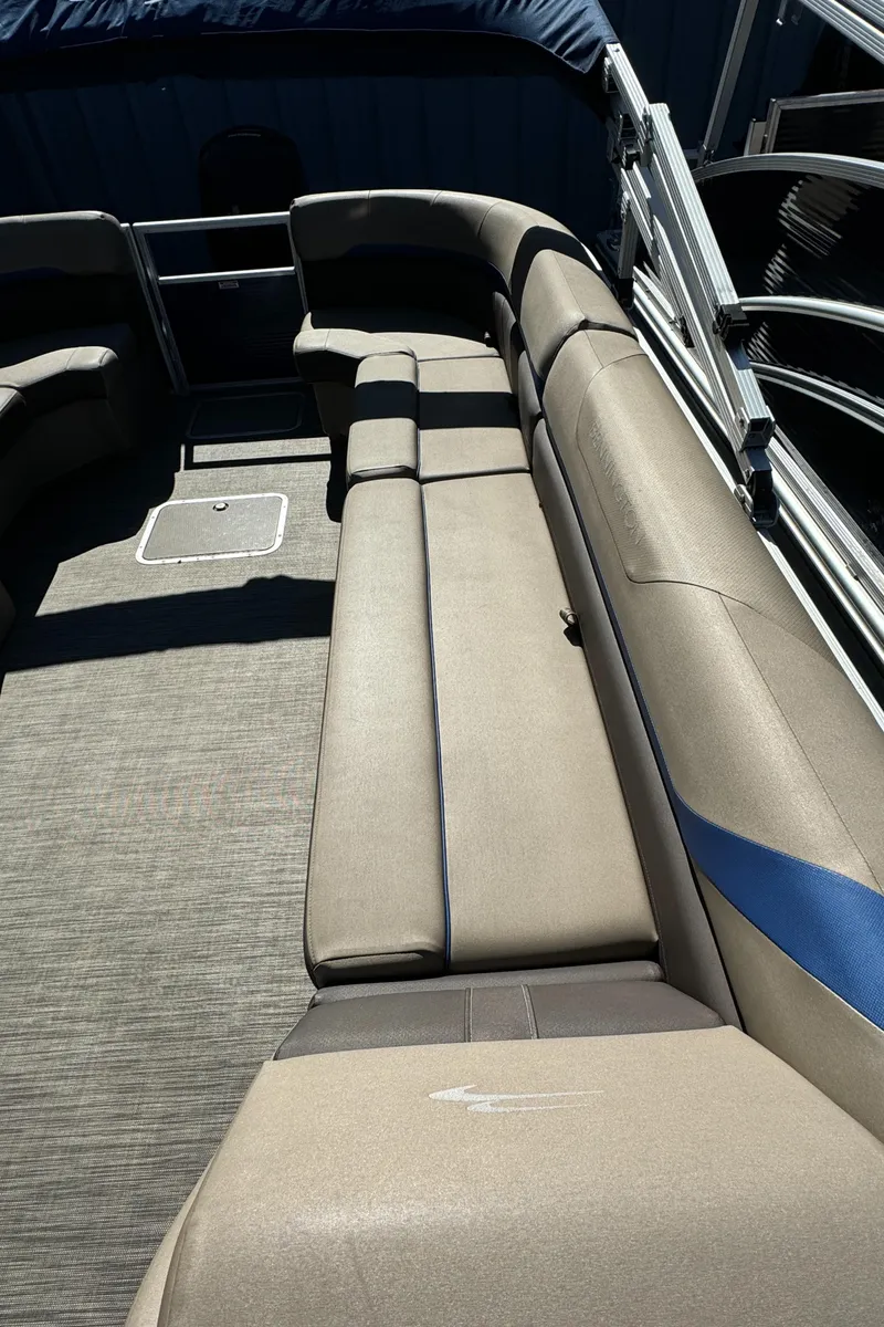 Slide: The Image of 2022 Bennington Cruiser 230 interior with beige seating and carpeted flooring. - 14