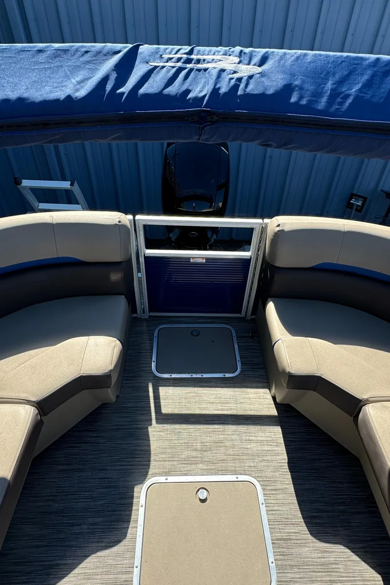 Slide: The Image of 2022 Bennington Cruiser 230 interior with beige seating and blue accents. - 22