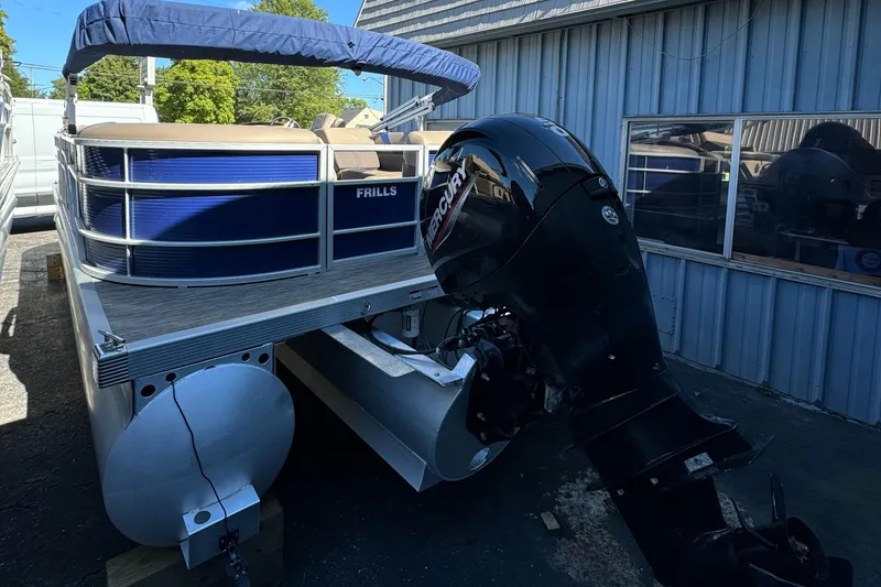 Slide: The Image of 2022 Bennington Cruiser 230 pontoon boat with Mercury outboard motor, docked near a metal building. - 7