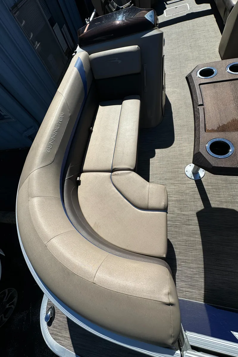 Slide: The Image of 2022 Bennington Cruiser 230 boat interior with beige seating and cup holders. - 9