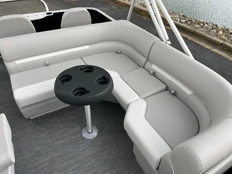 Slide: The Image of 2025 Godfrey Xperience 2086 FX boat interior with gray seating and round table. - 11