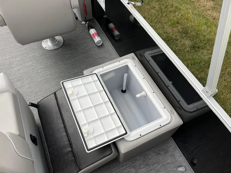 Slide: The Image of Open storage compartment on 2025 Godfrey Xperience 2086 FX boat, featuring seating and safety equipment. - 16