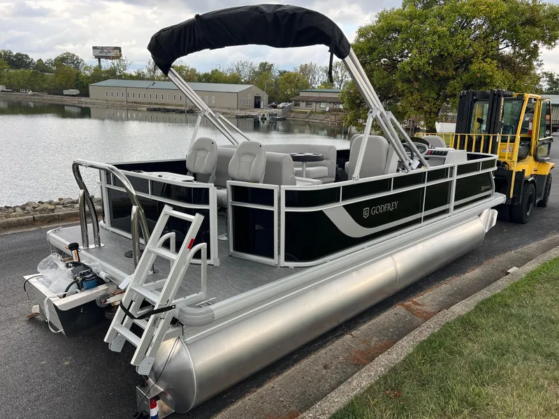 Slide: The Image of 2025 Godfrey Xperience 2086 FX pontoon boat by a lakeside, featuring sleek design and modern amenities. - 5