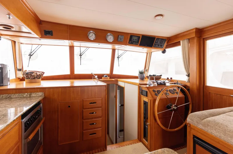Slide: The Image of 2005 Grand Banks Europa yacht interior with wooden helm and navigation instruments. - 13
