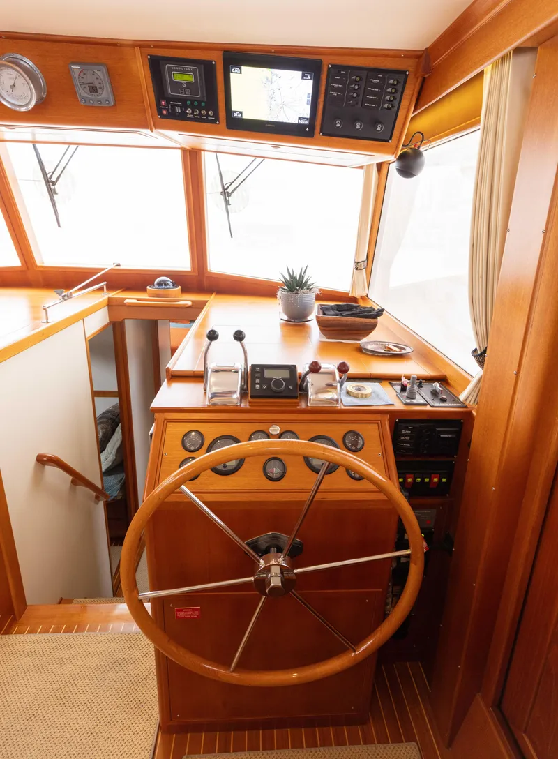 Slide: The Image of 2005 Grand Banks Europa helm with wooden steering wheel and navigation instruments. - 15