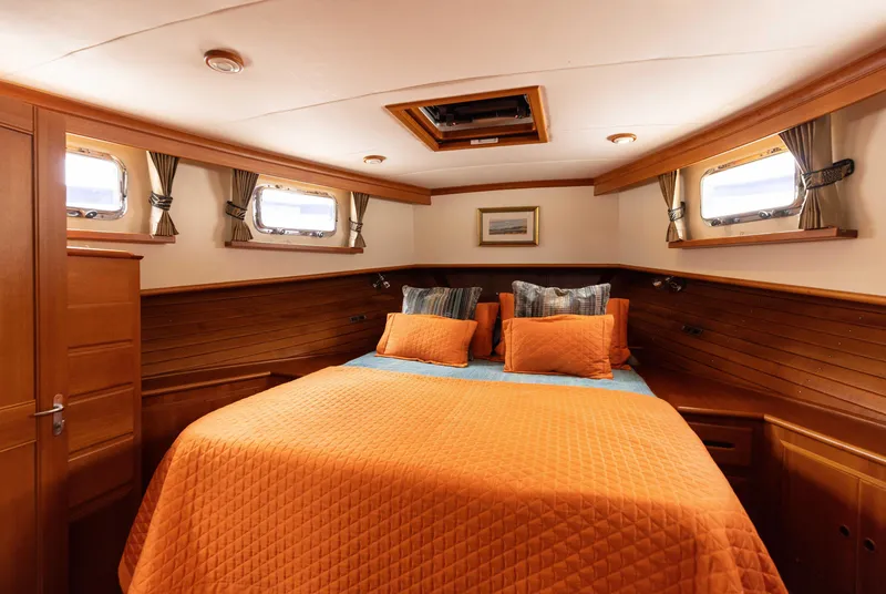 Slide: The Image of Cozy cabin interior of 2005 Grand Banks Europa yacht with orange bedding. - 18
