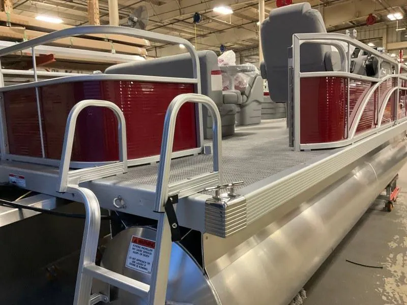 Slide: The Image of 2023 Bennington 20SVF pontoon boat with red accents and seating, in a warehouse setting. - 6