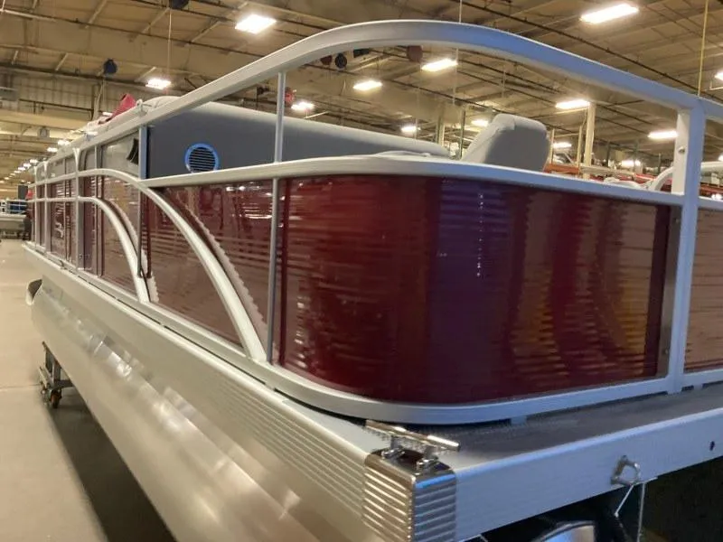 Slide: The Image of 2023 Bennington 20SVF pontoon boat with red paneling in a warehouse setting. - 7