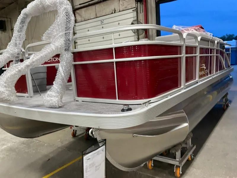 Slide: The Image of 2023 Bennington 20SVF pontoon boat in a warehouse, featuring a red exterior. - 8