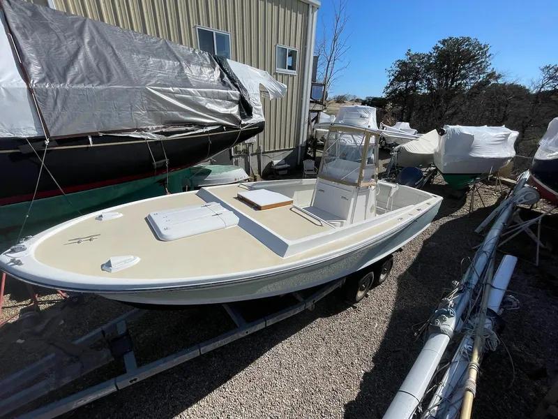 Slide: The Image of 1966 Bertram 25 Moppie boat on trailer, parked outdoors near other covered boats. - 3
