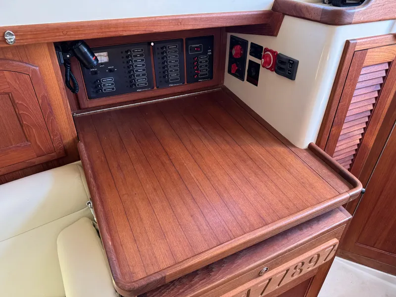 Slide: The Image of Navigation station of a 2006 Pacific Seacraft 31 sailboat with wooden finish and control panels. - 11