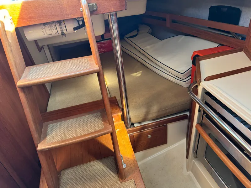 Slide: The Image of Interior of 2006 Pacific Seacraft 31 sailboat with wooden steps and cozy sleeping area. - 13