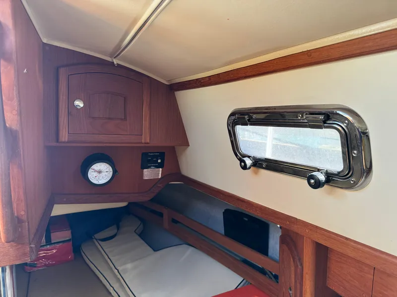 Slide: The Image of Interior cabin of 2006 Pacific Seacraft 31 sailboat with wooden cabinetry and porthole window. - 14