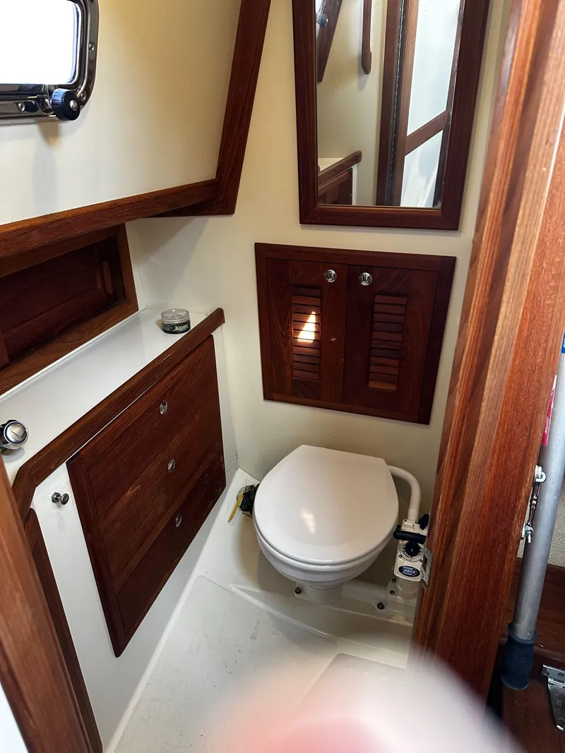 Slide: The Image of 2006 Pacific Seacraft 31 yacht bathroom with wooden cabinetry and compact toilet. - 16