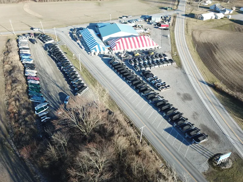 Slide: The Image of Aerial view of Lund 1650 Rebel XL Sport boats at a dealership, 2025 model, with striped tents. - 32