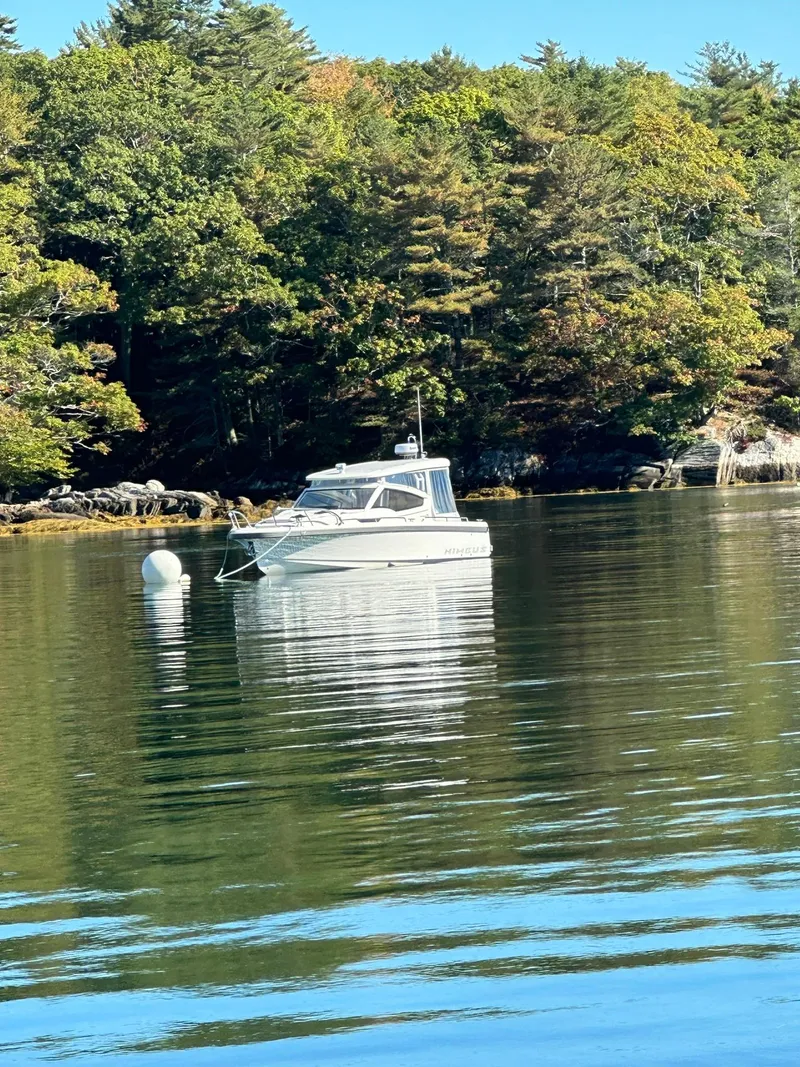 Slide: The Image of Nimbus W9 boat on calm water near forested shoreline, 2021 model. - 12