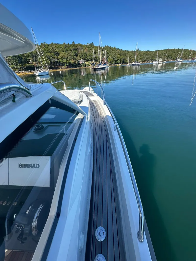 Slide: The Image of Nimbus W9 2021 boat on calm water near a forested shoreline. - 15