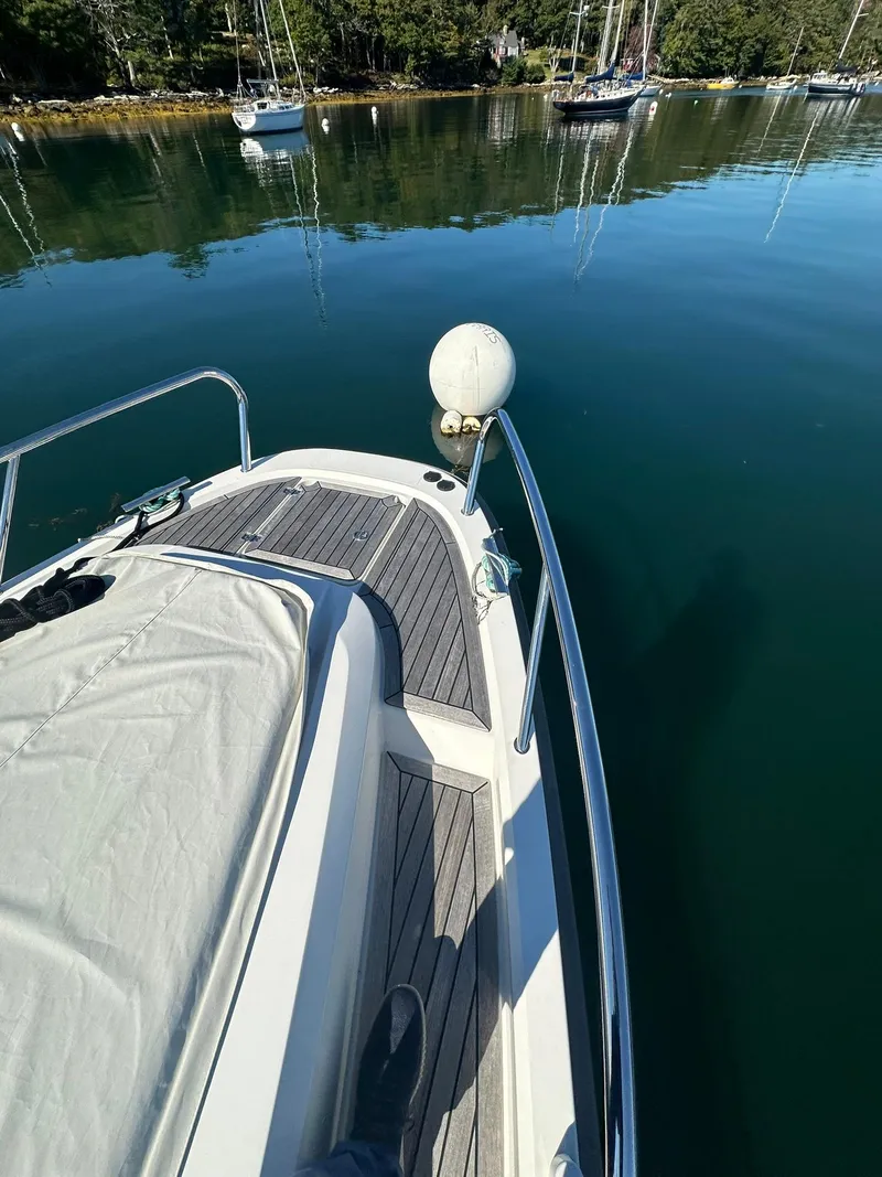 Slide: The Image of Nimbus W9 2021 boat docked on calm water with scenic background. - 17
