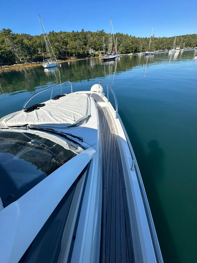 Slide: The Image of Nimbus W9 2021 boat on calm water with forested shoreline and sailboats. - 18