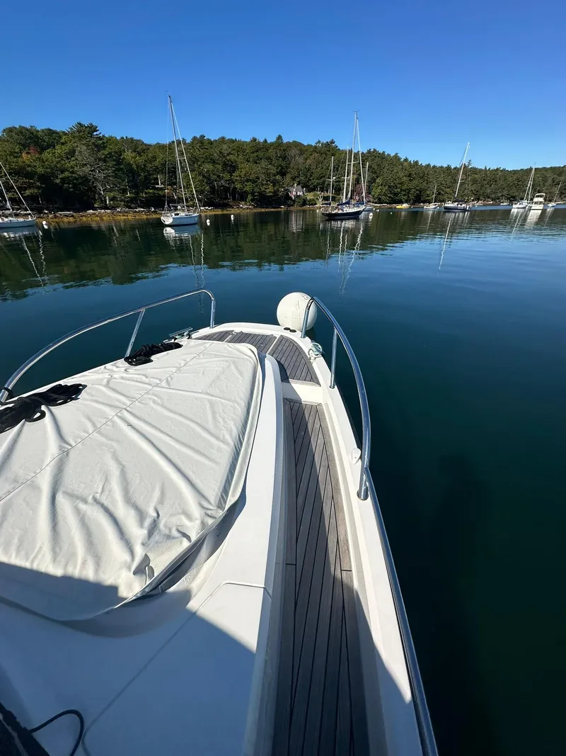 Slide: The Image of Nimbus W9 2021 boat on calm water with forested shoreline in background. - 19