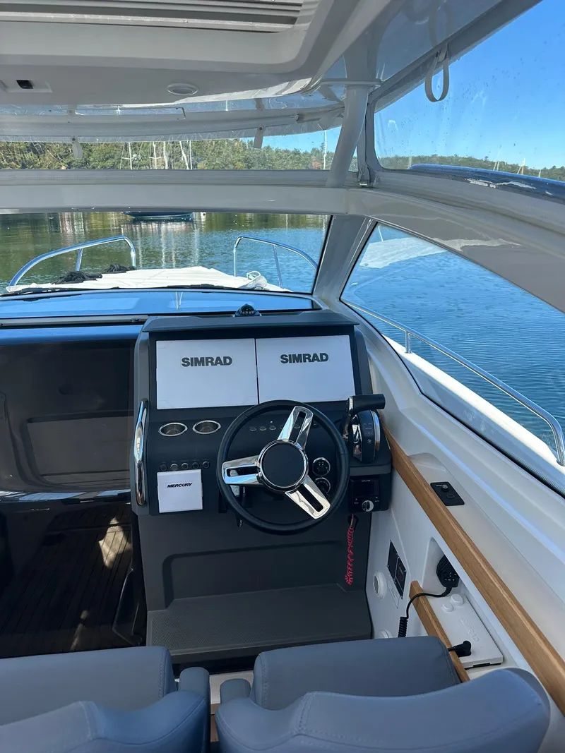 Slide: The Image of Interior of 2021 Nimbus W9 boat with Simrad navigation system and steering wheel. - 22