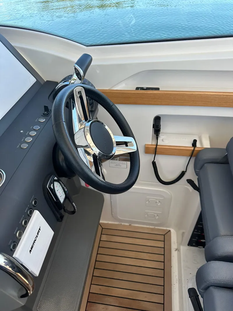 Slide: The Image of Nimbus W9 2021 boat interior with steering wheel and wooden flooring. - 24