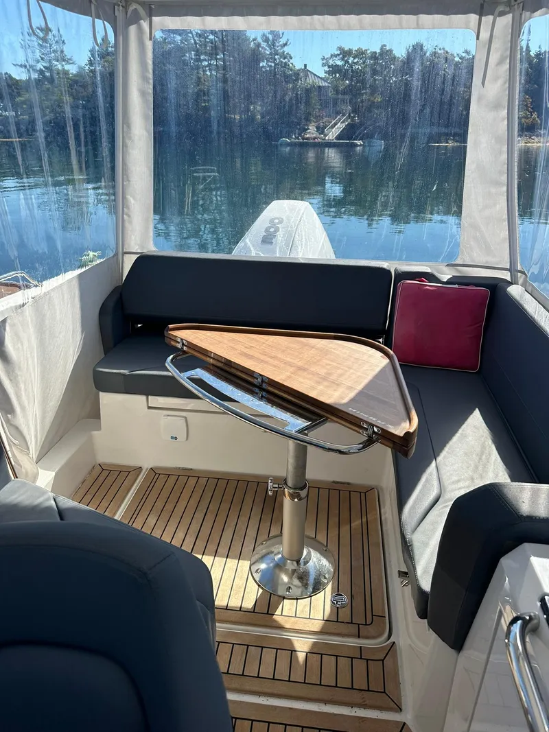 Slide: The Image of Interior of 2021 Nimbus W9 boat with wooden table and cushioned seating. - 27