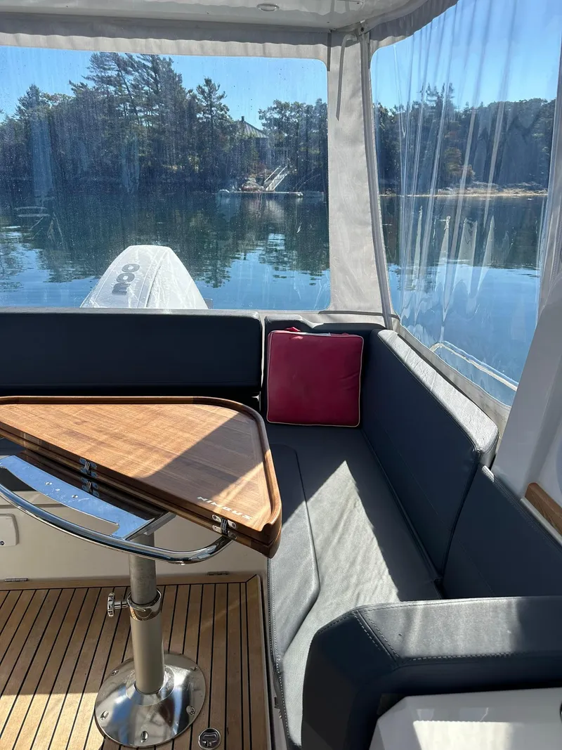 Slide: The Image of Interior of 2021 Nimbus W9 boat with wooden table and scenic lake view. - 41