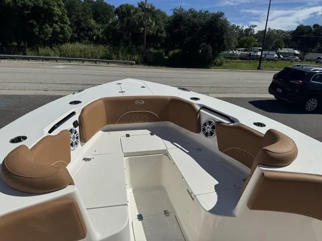 Slide: The Image of 2025 Key West 263 FS boat interior with tan seating and speakers. - 8