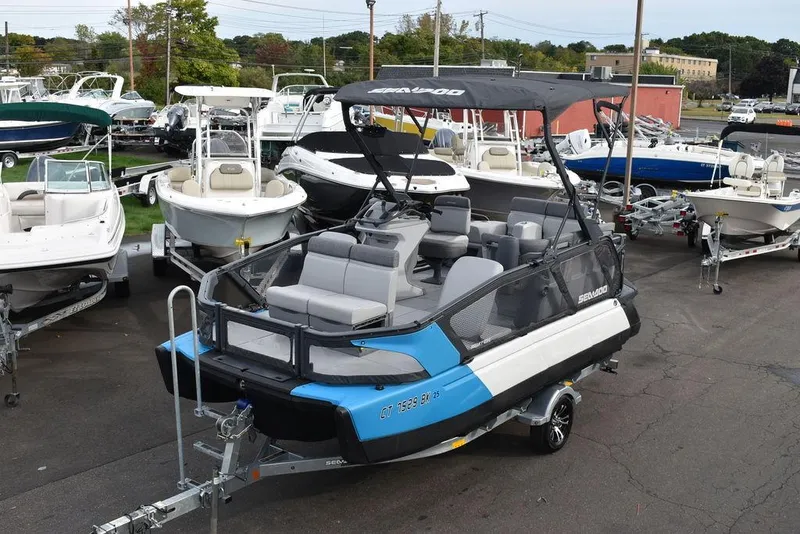 Slide: The Image of 2023 Sea-Doo Switch® Cruise 18-230 hp pontoon boat on trailer, surrounded by other boats. - 0