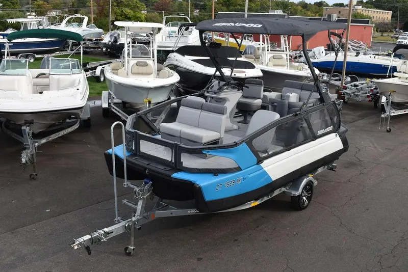 Slide: The Image of 2023 Sea-Doo Switch® Cruise 18-230 hp pontoon boat on trailer in marina. - 1