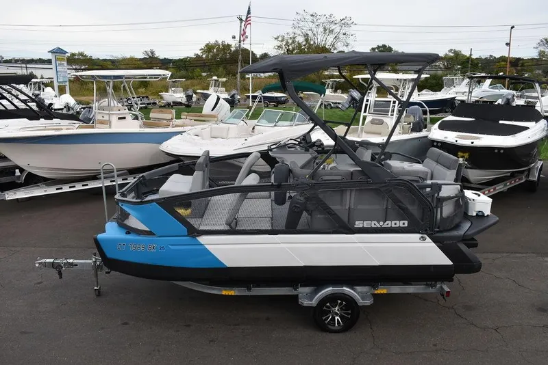 Slide: The Image of 2023 Sea-Doo Switch® Cruise 18-230 hp pontoon boat in a marina setting. - 2