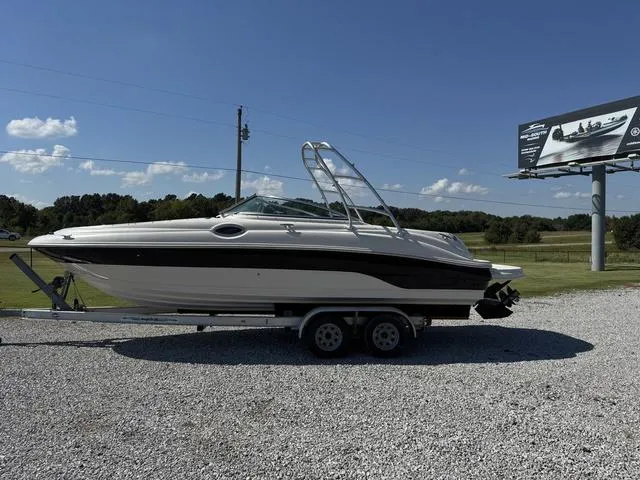 Slide: The Image of 2002 Sea Ray 240 Sundeck boat on trailer under clear blue sky. - 4
