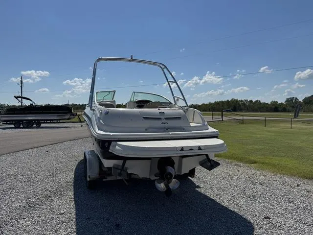 Slide: The Image of 2002 Sea Ray 240 Sundeck boat on trailer, parked on gravel under clear sky. - 5