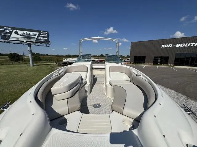 Slide: The Image of 2002 Sea Ray 240 Sundeck boat with spacious seating, parked outdoors under clear skies. - 8