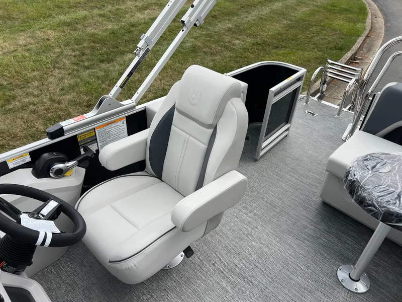 Slide: The Image of 2025 Godfrey Sweetwater 2286 C boat interior with captain's chair and steering wheel. - 14