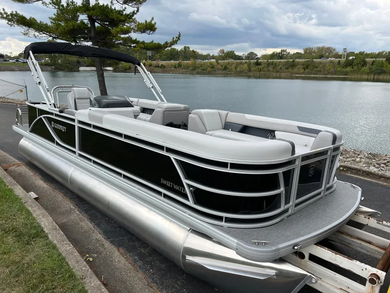 Slide: The Image of 2025 Godfrey Sweetwater 2286 C Special Edition pontoon boat by a serene lake. - 3