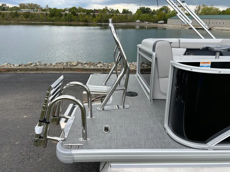 Slide: The Image of 2025 Godfrey Sweetwater 2286 C Special Edition pontoon boat by a lake. - 6