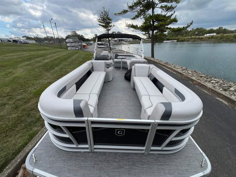 Slide: The Image of 2025 Godfrey Sweetwater 2286 C Special Edition pontoon boat docked by a scenic lake. - 7