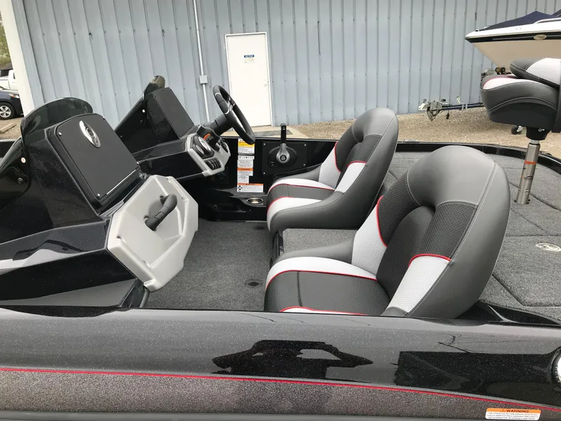 Slide: The Image of 2025 Ranger Z185 boat with spacious deck, parked near a storage facility. - 10