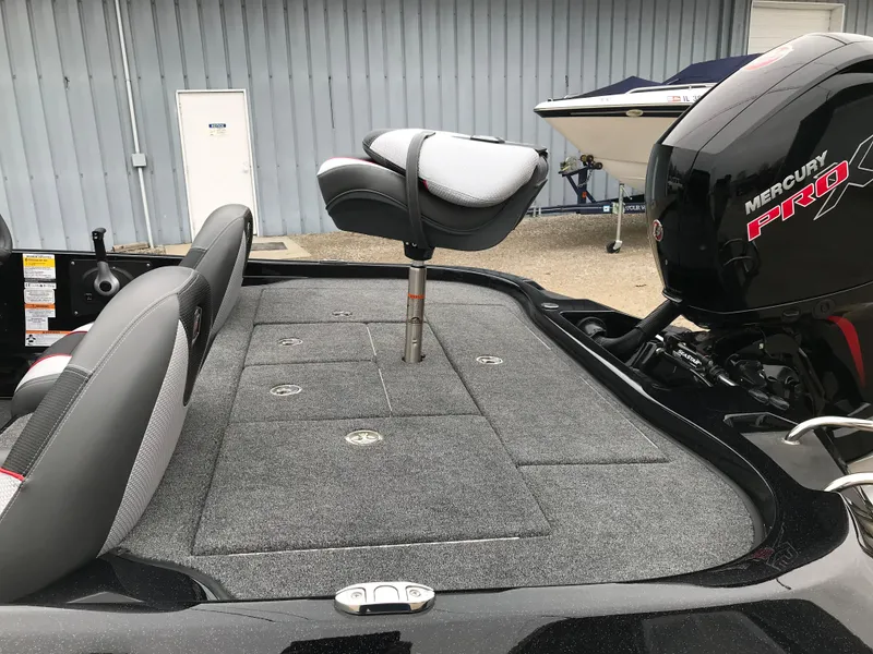 Slide: The Image of 2025 Ranger Z185 boat interior with modern seating and steering, parked outdoors. - 12