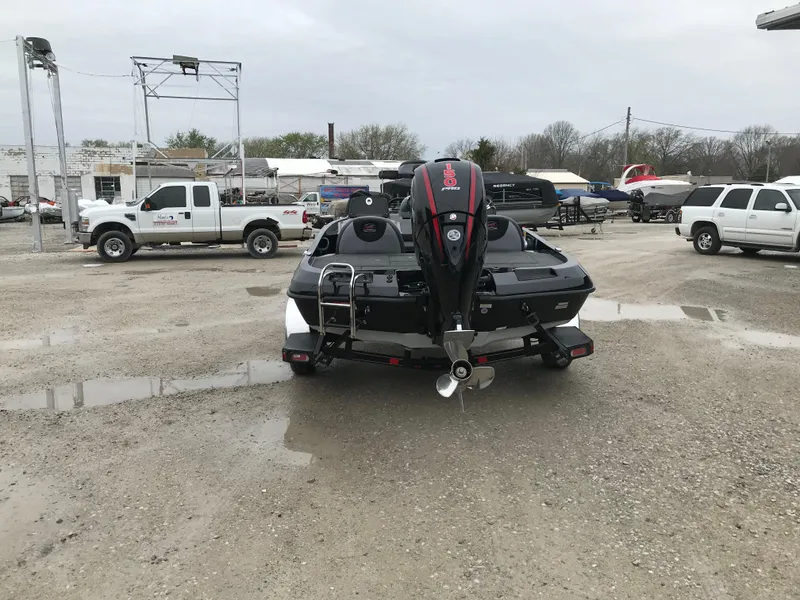 Slide: The Image of 2025 Ranger Z185 boat with motor, parked on gravel near a metal building. - 3