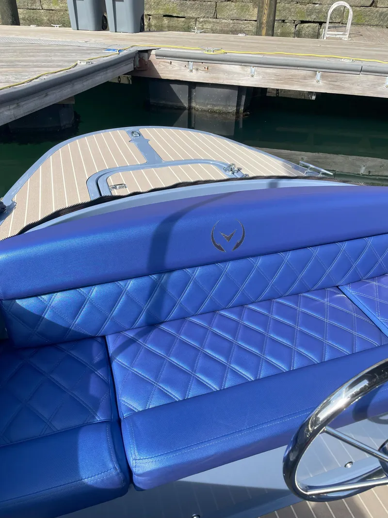 Slide: The Image of 2024 Vision Marine Technologies Fantail 217 with blue quilted seating at a dock. - 10