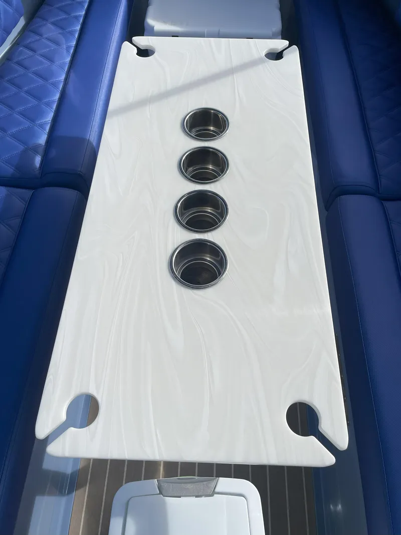 Slide: The Image of 2024 Vision Marine Technologies Fantail 217 boat interior with white table and blue seating. - 6