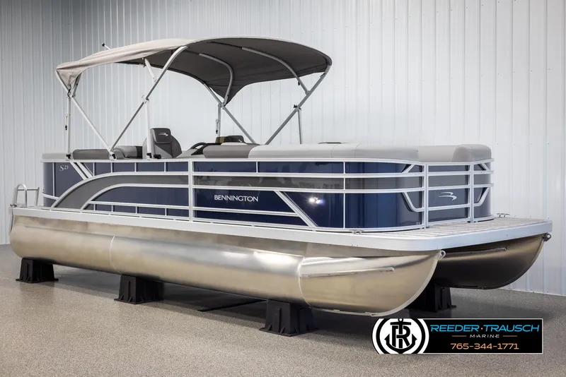 Slide: The Image of 2025 Bennington 23 SSRSE pontoon boat with canopy, displayed indoors on stands. - 3