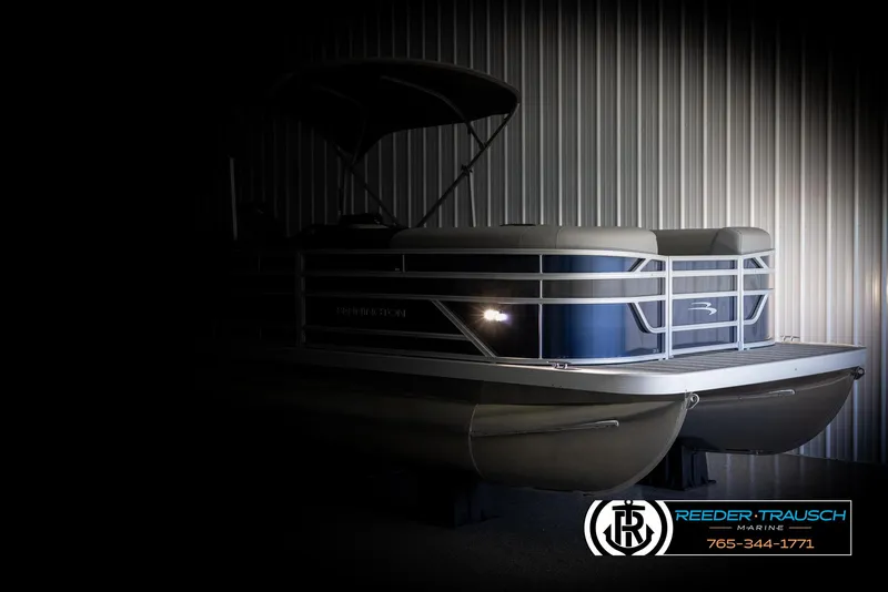 Slide: The Image of 2025 Bennington 23 SSRSE pontoon boat in a dimly lit showroom. - 4