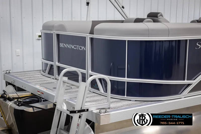 Slide: The Image of 2025 Bennington 23 SSRSE pontoon boat in showroom, featuring sleek design and modern seating. - 43